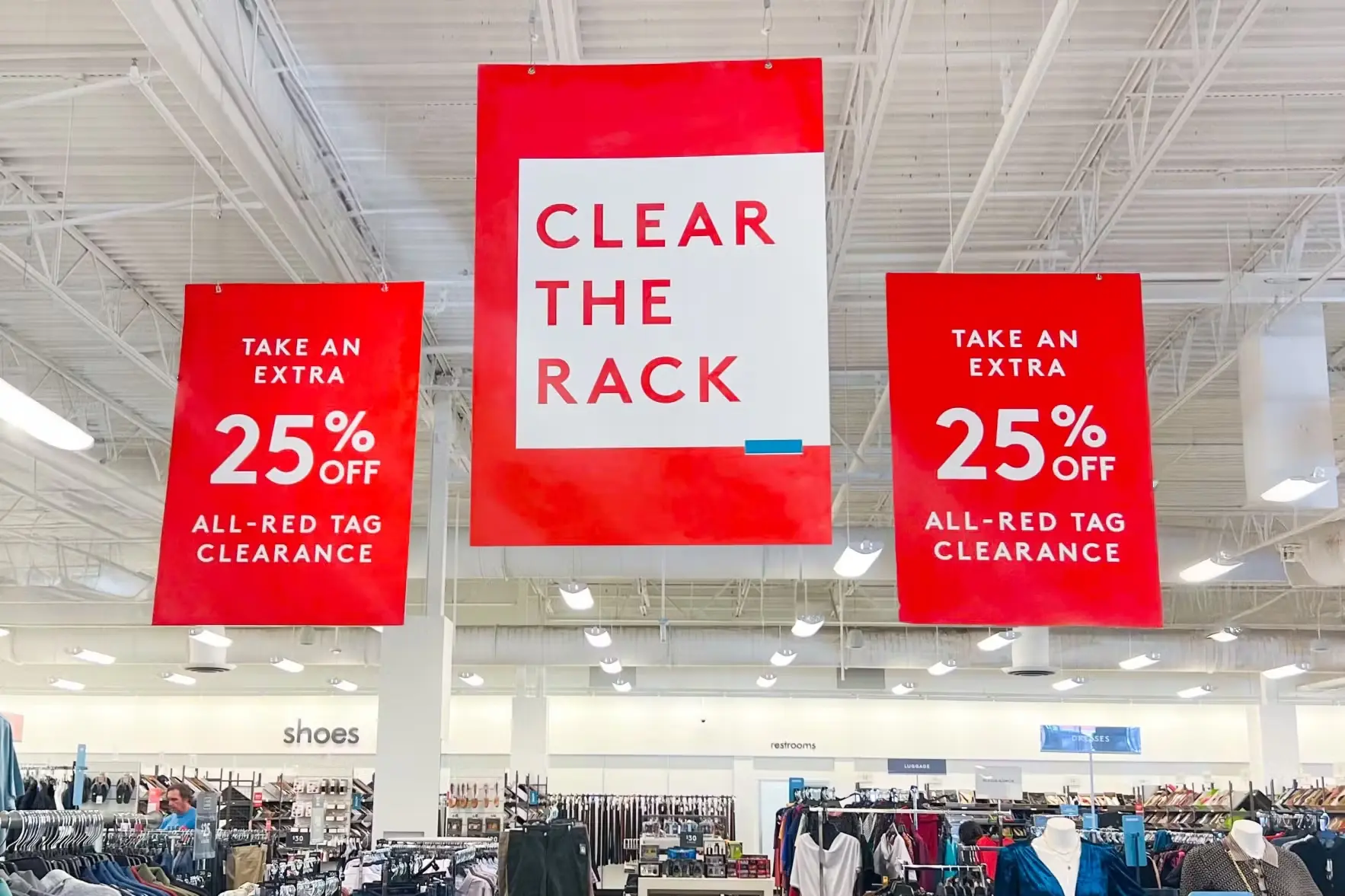 Retail store clearance sale signs showing 25% off discounts on all red tag clearance merchandise